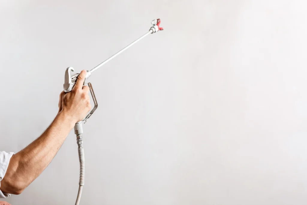 worker-painting-wall-with-spray-gun-white