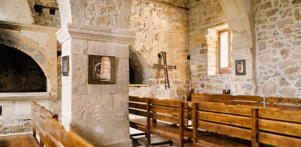 Captivating view of a historic stone church interior with wooden pews and arched architecture.