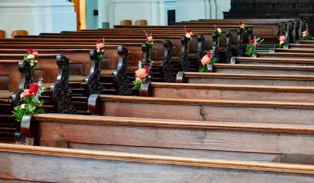 Rows of empty wooden pews inside a church
