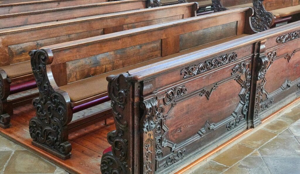 A close-up view of empty antique wooden pews