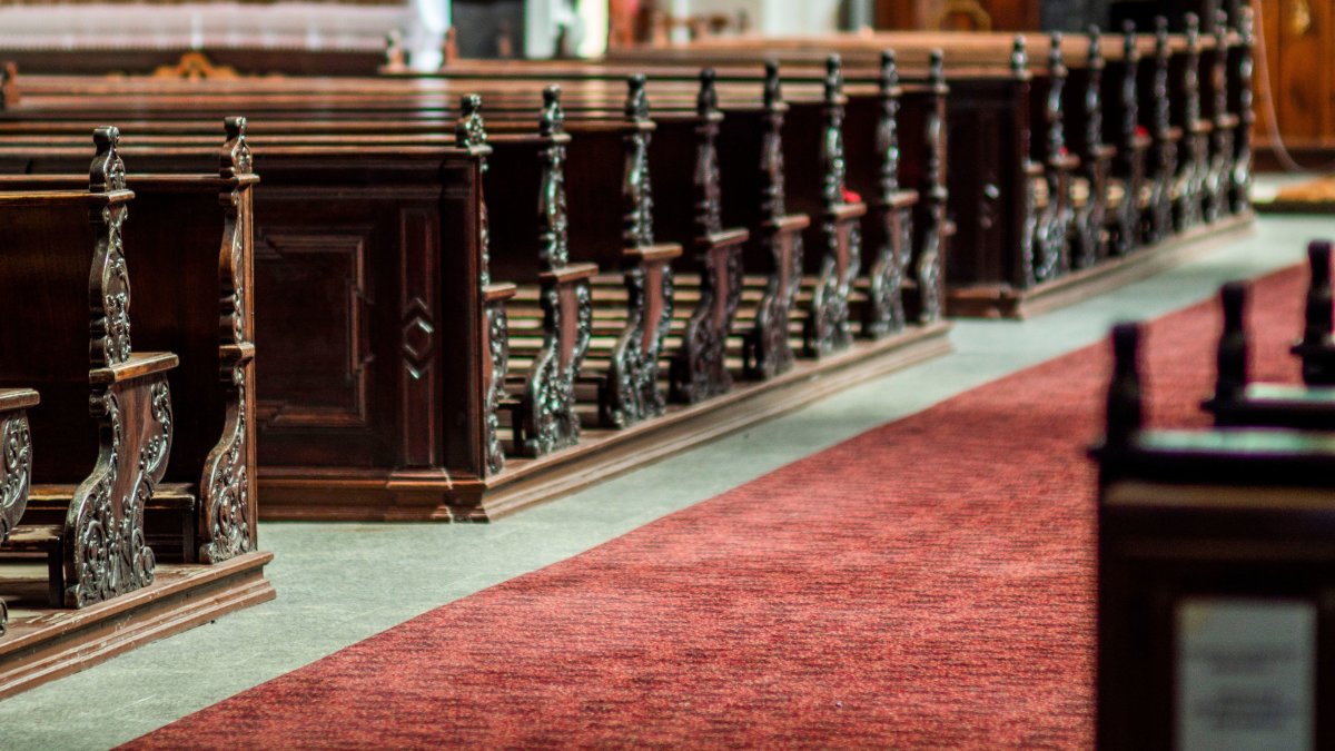 Detailed view of ornate wooden pews in an empty church interior, showcasing timeless classical design.
