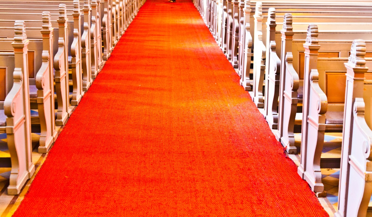 red carpet runner down the center aisle of a church