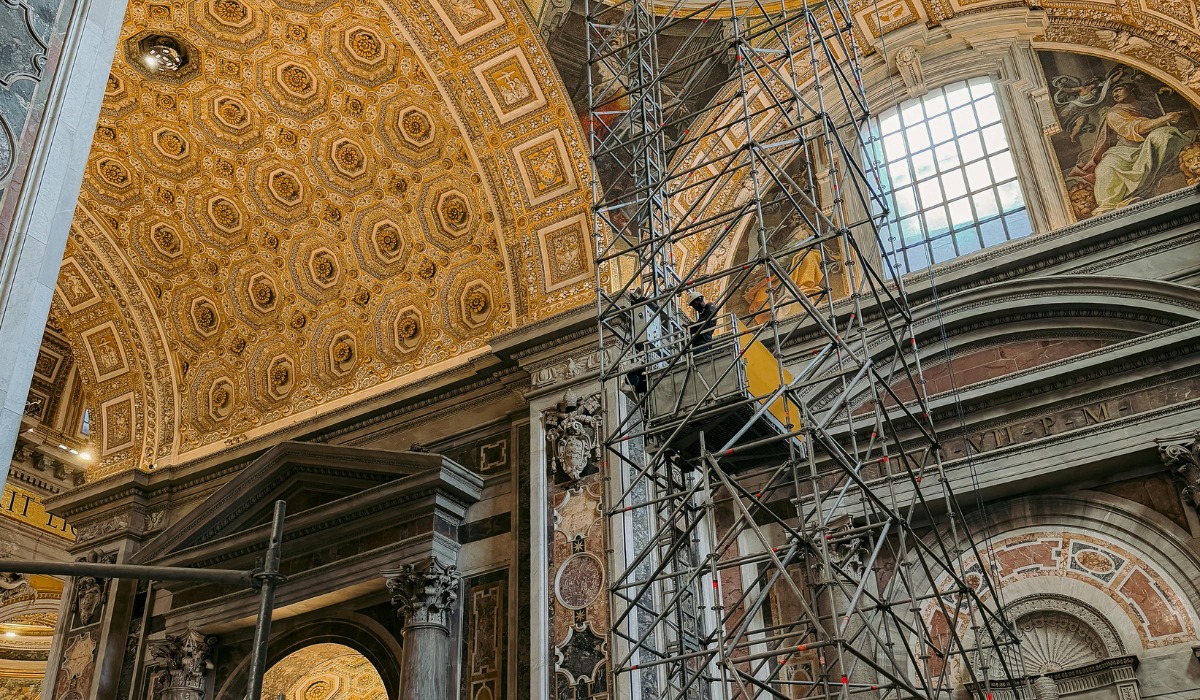 Workers on scaffolding inside a grand cathedral