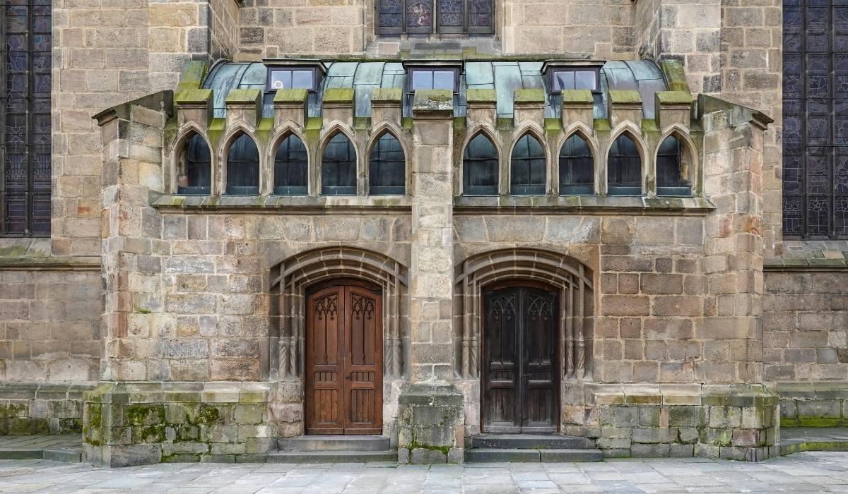 Two arched entryways featuring distinct wooden double doors