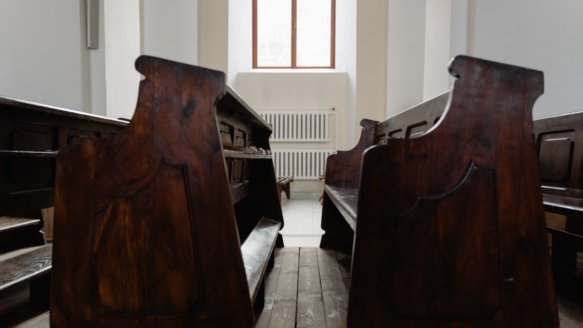Serene church interior with warm natural light illuminating wooden pews.